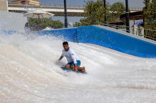 a young man riding a wave ride on a water slide at Grand Hyatt Dubai Resort & Waterpark in Dubai