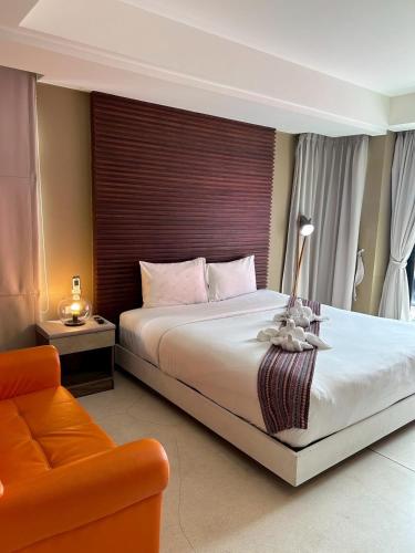 a bedroom with a large bed and a orange couch at Coco boutique hotel in Patong Beach
