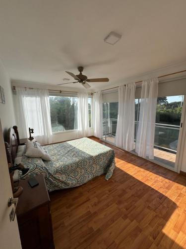 ein Schlafzimmer mit einem Bett und einem Deckenventilator in der Unterkunft Casa La Emiliana Playa Chapadmalal in La Estafeta