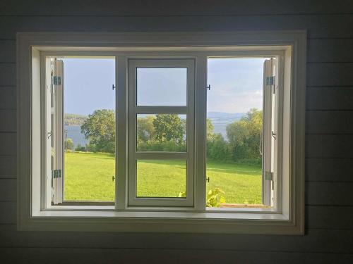 an open window with a view of a green field at Lovely tiny house with a dream view ! 