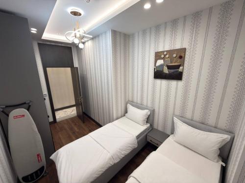 タシュケントにあるAsiaWay Apartment-NEST ONEの天井の小さな客室で、ベッド2台が備わります。