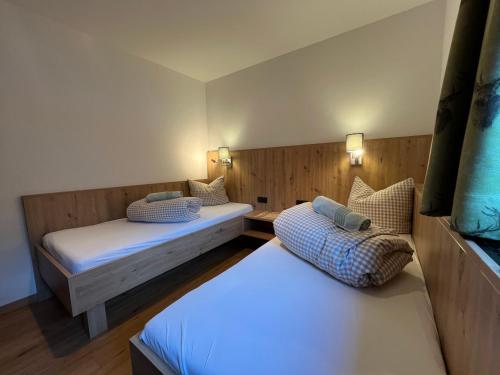 Cette chambre comprend 2 lits et 2 lampes murales. dans l'établissement Pittlanderhof, à Innsbruck