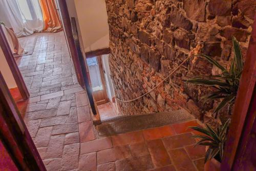 un couloir en pierre avec un mur en pierre et un sol en pierre dans l'établissement Casa di Vignolo, à Pergine Valdarno