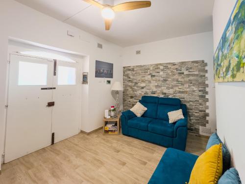 a living room with a blue couch and a brick wall at casale nonna Elisa relax tra ulivi in San Vito Chietino