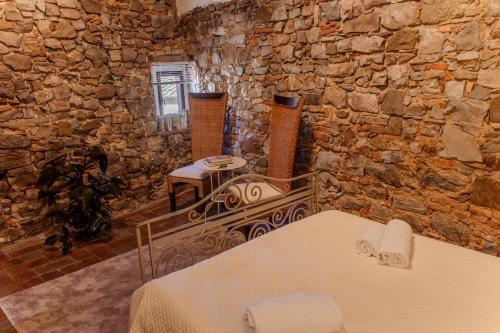 Cette chambre est dotée d'un mur en pierre, d'une table et de chaises. dans l'établissement Casa di Vignolo, à Pergine Valdarno