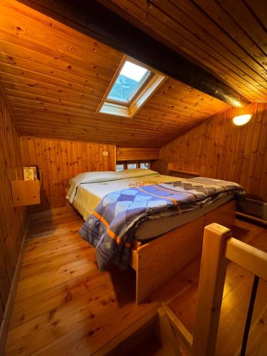 a bedroom with a bed in a wooden cabin at La Casetta del Picchio in Caspoggio
