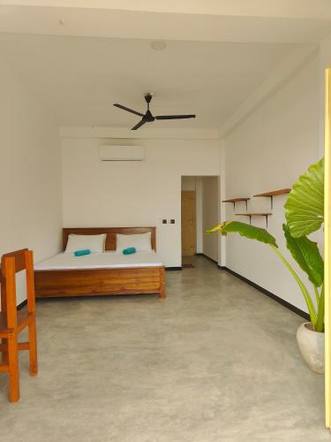 Un dormitorio con una cama y un ventilador de techo. en The Sun Set, en Weligama