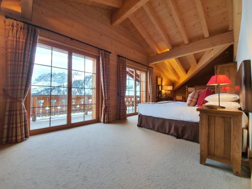een slaapkamer met een bed en een groot raam bij Mountain Lodge, Les Crosets in Les Crosets