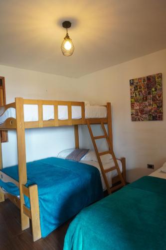 a bedroom with two bunk beds and a ladder at La Fogata del Sur in Fundo Copacabana