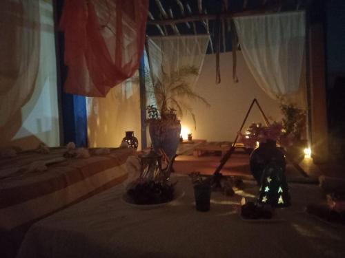 een kamer met 2 bedden en een tafel met verlichting bij Art Of Balance in Tamraght Ouzdar