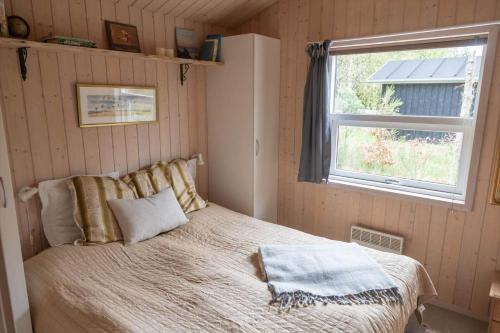 um quarto com uma cama e uma janela em JB827-Fjerritslev-Revlingestien-93 em Torup Strand