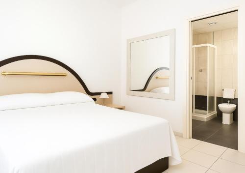 ミラノにあるSechi Hotel Milanoの白いベッドルーム(白いベッド1台付)、バスルームが備わります。