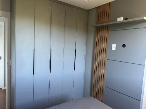 a bedroom with white cabinets and a refrigerator at Denny Prime Loft - Executive Apartment in Extrema in Extrema