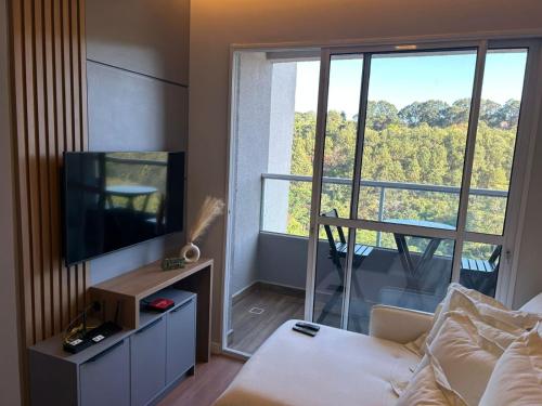 a living room with a couch and a large window at Denny Prime Loft - Executive Apartment in Extrema in Extrema