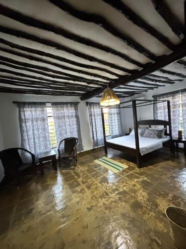 a bedroom with a bed in a room with windows at Villa Kazungu in Ukunda