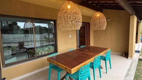 una mesa de comedor con sillas azules y candelabros en Refúgio de Luxo 11 Hospedes 500m Praia de Pitinga, en Porto Seguro
