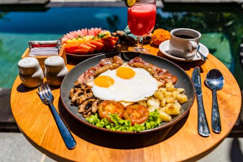 ein Tisch mit einem Teller mit Essen mit Eiern und Gemüse in der Unterkunft Ellena Resort Tegallalang by Dhananjaya Hospitality in Tampaksiring