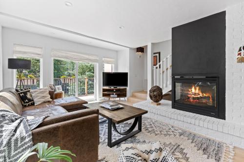 a living room with a couch and a fireplace at Modern Alpine Retreat at Vail in Vail