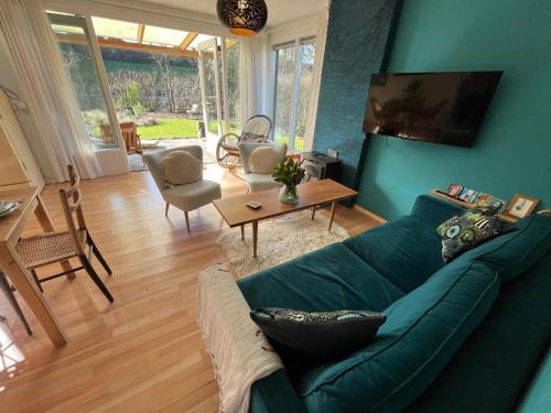 un soggiorno con un divano verde e un tavolo di Vakantiebungalow Vrijzicht a Kortgene