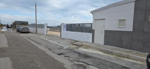 an empty street with cars parked next to a building at Home Design La Vela in Zapponeta