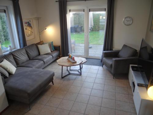 a living room with a couch and a table at Holidayhouse Noordzee in Kamperland