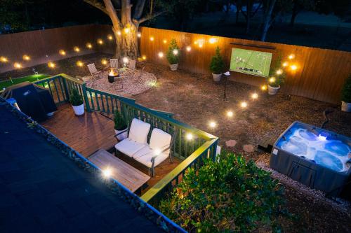 a deck with a chair and a television and lights at Speakeasy, Hot Tub, Putt Putt, Outdoor Theatre, 8 minutes from Downtown Greenville in Greenville