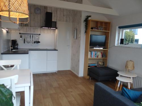 a kitchen and living room with a couch and a table at Holidayhouse Akkerrand Kamperland in Kamperland