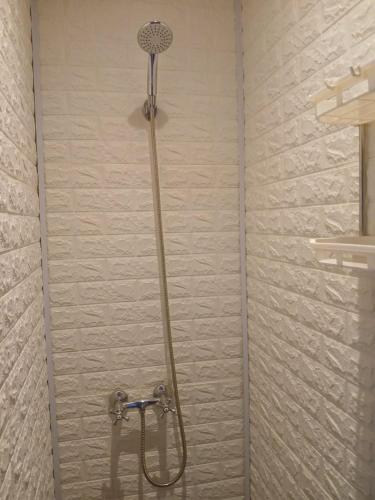 a shower with a shower head in a bathroom at El Kamaruco Hostel in El Chalten
