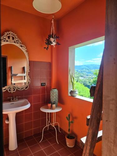 a bathroom with a sink and a mirror and a window at Casba Hostel in Las Terrenas