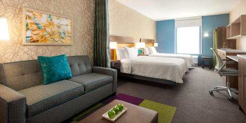 a hotel room with a couch and a bed at Home2 Suites By Hilton Salisbury Fruitland in Fruitland