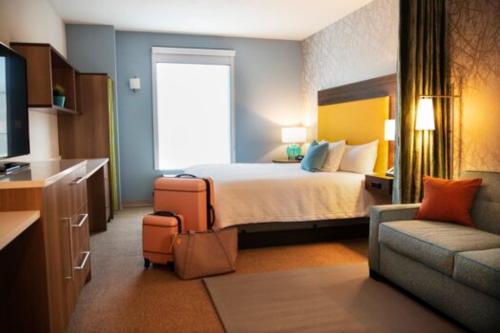 a hotel room with a bed and a couch at Home2 Suites By Hilton Salisbury Fruitland in Fruitland