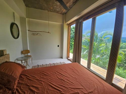 a bedroom with a bed and a large window at Casba Hostel in Las Terrenas