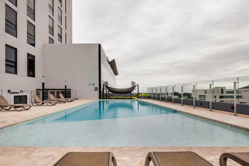 a large swimming pool on top of a building at Moderno Depa a 3 mins de Fundidora y Tec de Mty in Monterrey
