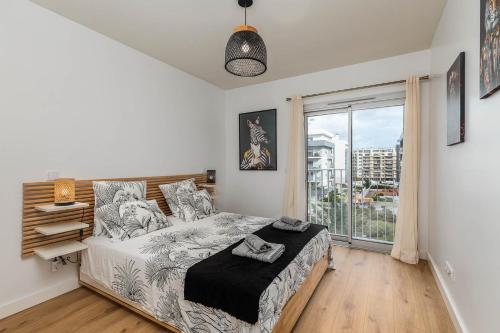 ein Schlafzimmer mit einem Bett und einem großen Fenster in der Unterkunft Lisbon South Bay - Orizon Seixal in Seixal