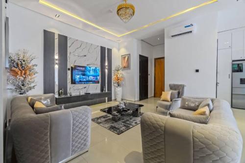 Una sala de estar con dos sofás y un televisor. en Yomsdale Air B N B, en Lekki