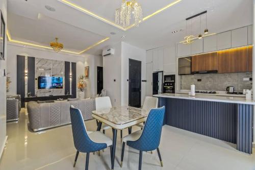 Una cocina y un comedor con una mesa y sillas azules. en Yomsdale Air B N B, en Lekki