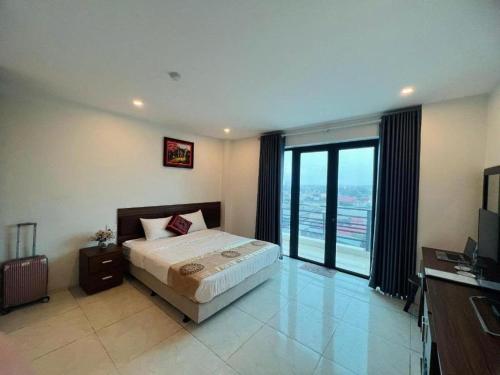 a bedroom with a bed and a large window at Mạnh Quỳnh Hotel in Tinh Xa