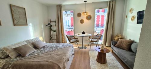 a living room with a couch and a table at L'épure - Clim - Confort - Moderne in Lourdes