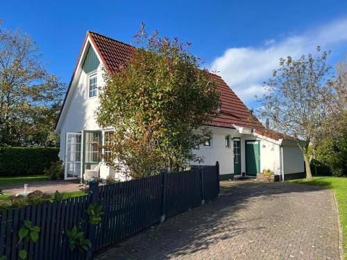 una casa bianca con una recinzione davanti di Vakantiewoning Westhoek a Kortgene