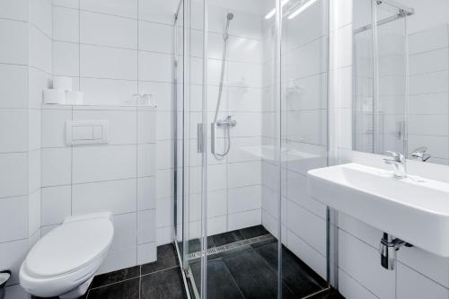 um banheiro branco com um vaso sanitário e uma pia em 7Days B&B em Bratislava