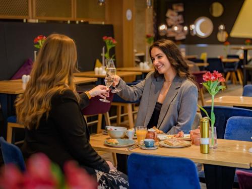 ハノーファーにあるメルキュール ホテル ハノーファー シティのワインを飲む二人の女