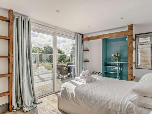 ウエストワード・ホーにある2 Bed in Westward Ho 41132のベッドと大きな窓のある寝室