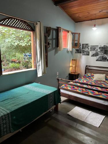 a bedroom with two beds and a window at Vila Caribé in Lençóis