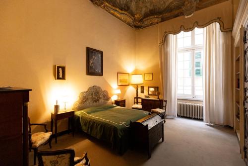 ein Schlafzimmer mit einem Bett und einem großen Fenster in der Unterkunft Palazzo Sinibaldo Fieschi in Genua