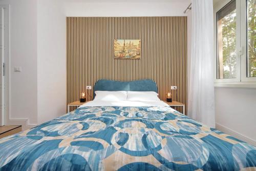 a bedroom with a blue and white bed and a window at Foro Italico Guesthouse in Rome