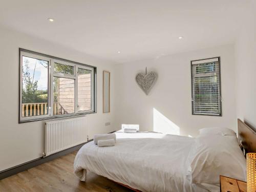 une chambre blanche avec un lit et deux fenêtres dans l'établissement 2 Bed in Westward Ho 95625, à Westward Ho