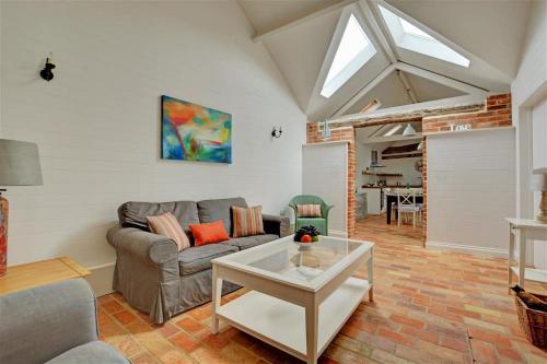 ein Wohnzimmer mit Sofa und Tisch in der Unterkunft Simons Barn in Langham