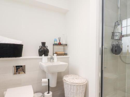a white bathroom with a sink and a shower at Mellings Place in Carnforth
