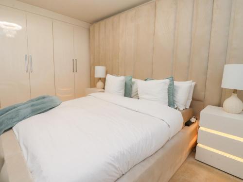 a bedroom with a large white bed and white cabinets at Mellings Place in Carnforth