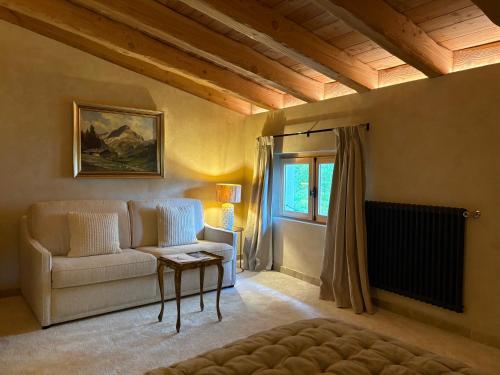 a living room with a couch and a window at Hôtel Le Prieuré - Pra Loup 1500 in Pra-Loup